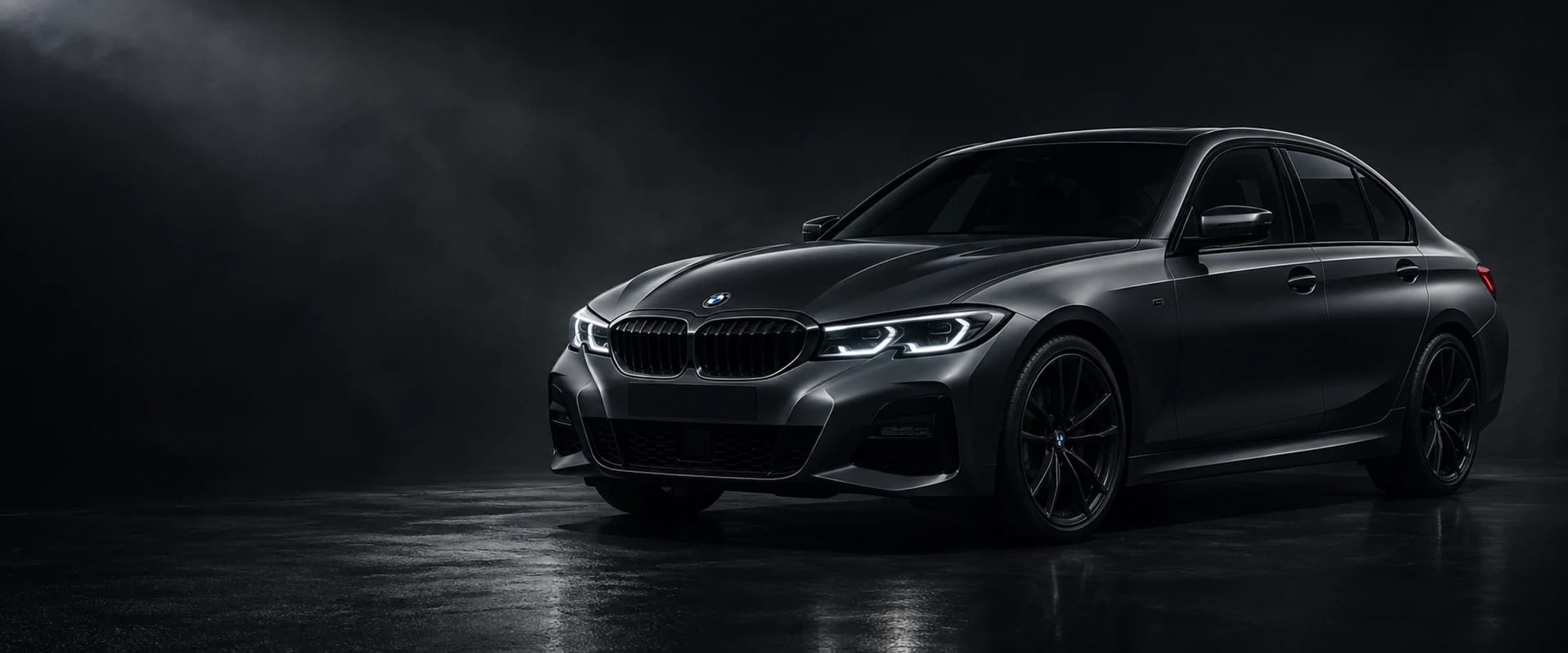 A gunmetal sedan revealed by studio light